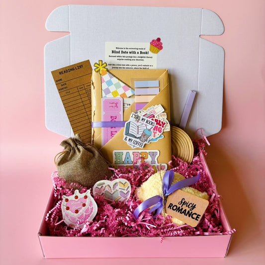 Gift box with stationery items on a pink background