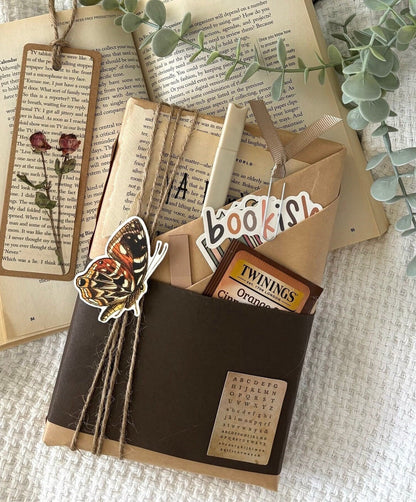 Blind date with book featuring a mystery book wrapped in kraft paper, perfect as a book gift or reading gift for book lovers and romantasy fans. Includes optional book accessories like a reading log and smut stickers. A great bookstagram worthy treat yourself moment or book club surprise. Ideal for booktok fans, dark romance lovers, or anyone seeking a book-only version of a mystery box gift, smut box, or book lover gift box with vintage vibes and cozy charm.