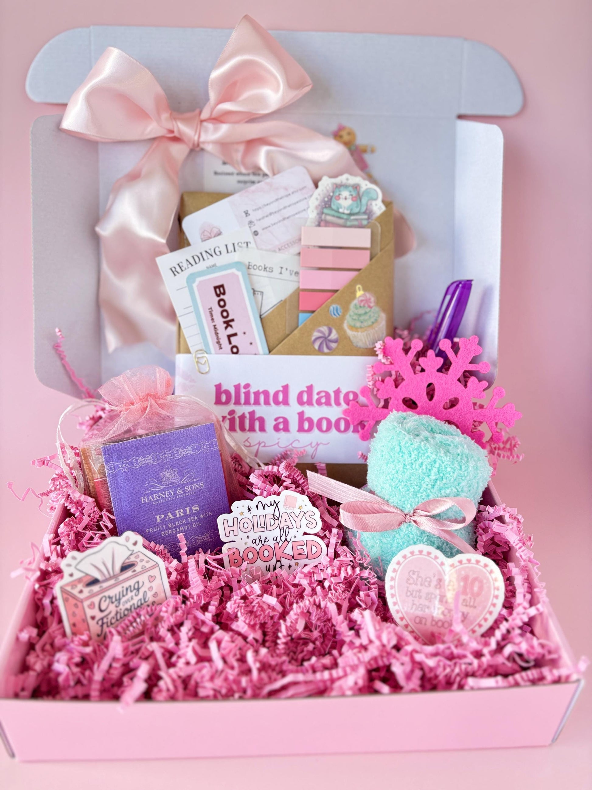 Whimsical christmas blind date with a book flat lay featuring pink wrapping, cocoa, and festive sparkle. Perfect for blind date with a book smut readers who adore bookish Christmas gifts and cozy holiday mysteries.