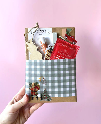 A magical christmas blind date with a book wrapped in icy blue and silver, perfect for romantasy fans. This blind date with a book box includes cocoa, socks, and a mystery novel—ideal for readers of blind date with a book dark romance.